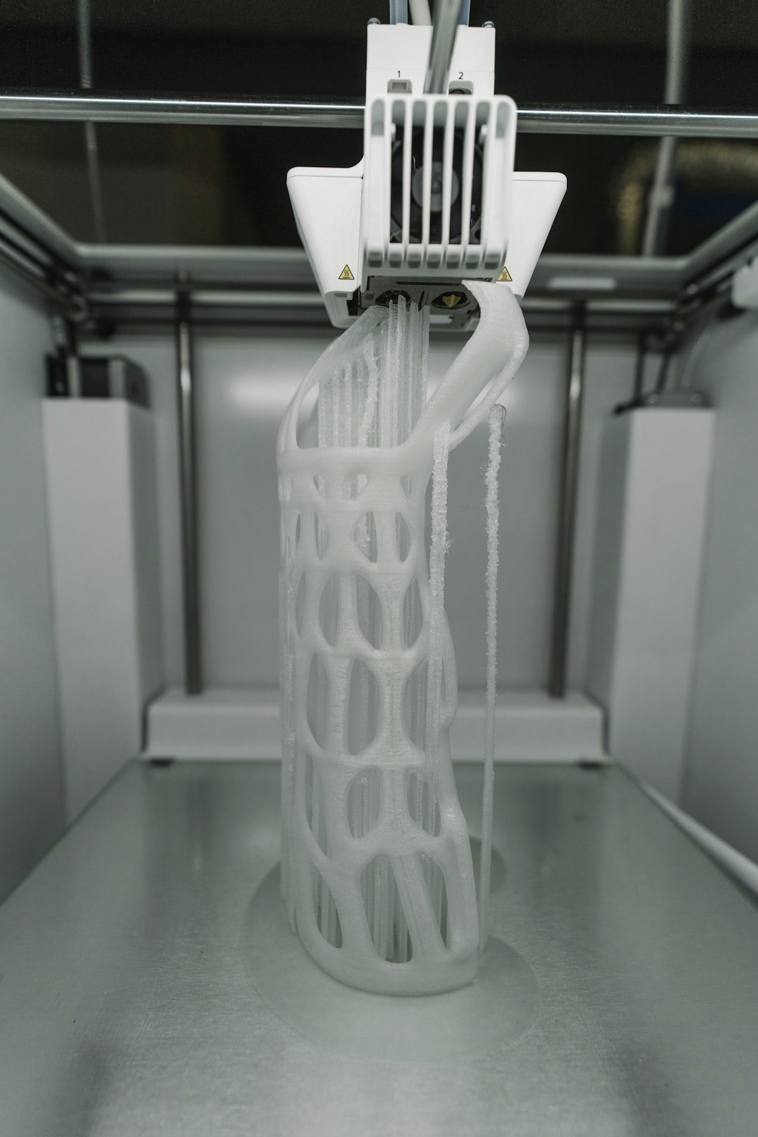 3D printer creating a detailed white lattice object.